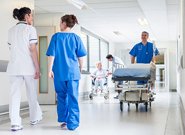 Nous intervenons sur différents secteurs tel que les hopitaux Présentation d'un hôpital avec plusieurs infirmières et brancardier qui traversent les couloirs